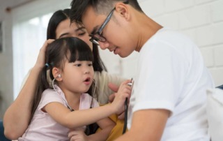 Child engaging in a playful activity with parents during a developmental session at a clinic supporting kids in Phnom Penh