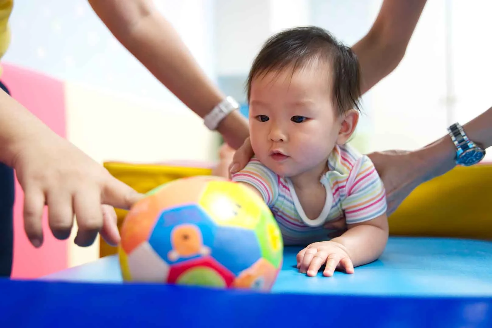 Young child participating in occupational therapy activities to improve motor skills, with colorful toys and supportive therapist in Phnom Penh.