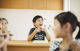 Group of children participating in a speech therapy session, smiling and practicing communication skills in Phnom Penh