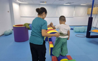 Child developing balance and coordination through guided therapy activity at a Phnom Penh learning support center