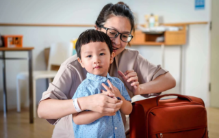 A mother gently helps her young son prepare for a transition, reflecting the importance of routine and language in supporting daily changes.