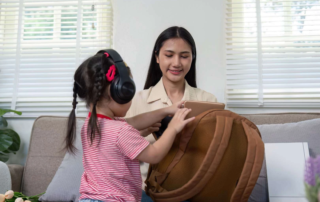 Young child with headphones practicing daily routine skills with therapist during occupational therapy session in Phnom Penh