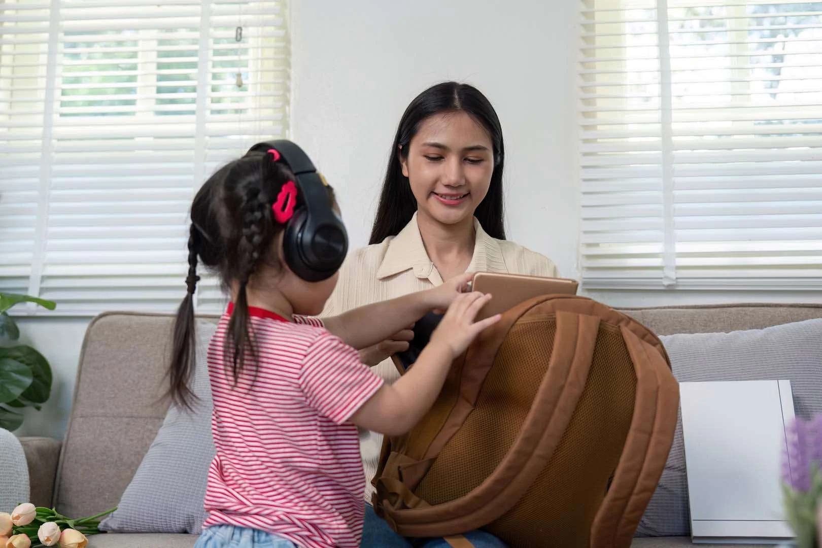 Young child with headphones practicing daily routine skills with therapist during occupational therapy session in Phnom Penh
