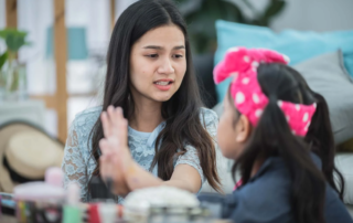 A speech therapist in Phnom Penh helps a young girl recognize and label emotions during a one-on-one therapy session at OrbRom Center.