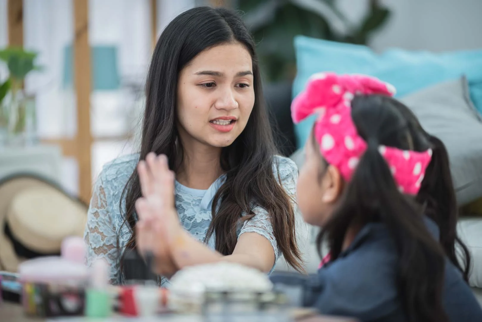 A speech therapist in Phnom Penh helps a young girl recognize and label emotions during a one-on-one therapy session at OrbRom Center.