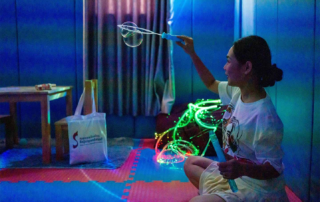 Therapist at OrbRom Center using bubble wands and fiber optic lights in a sensory room to support regulation in children with autism