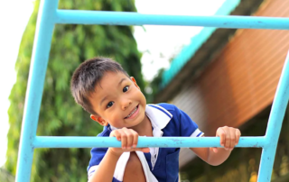 Smiling child playing outdoors at a development school in Phnom Penh, part of a special program for kids