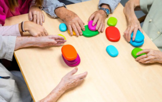 Elderly individuals and therapists engaging in a group fine motor activity session as part of occupational therapy in Phnom Penh