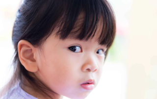 Young girl looking anxious and silent, possibly experiencing selective mutism, needing speech therapy support in Phnom Penh
