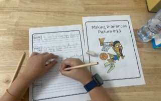 Student completing a making inferences worksheet activity with visual prompts and writing support at OrbRom Center Phnom Penh