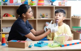 Clinician using Tongue Tip Lateralization & Elevation Tools during speech therapy session at OrbRom Center Phnom Penh