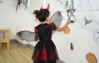 Children participating in a structured Halloween-themed preschool morning with decorated learning areas at OrbRom Center.