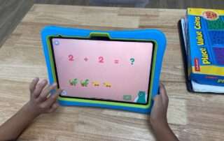 Child practicing early math skills on a tablet at OrbRom Center using Khan Academy Kids.