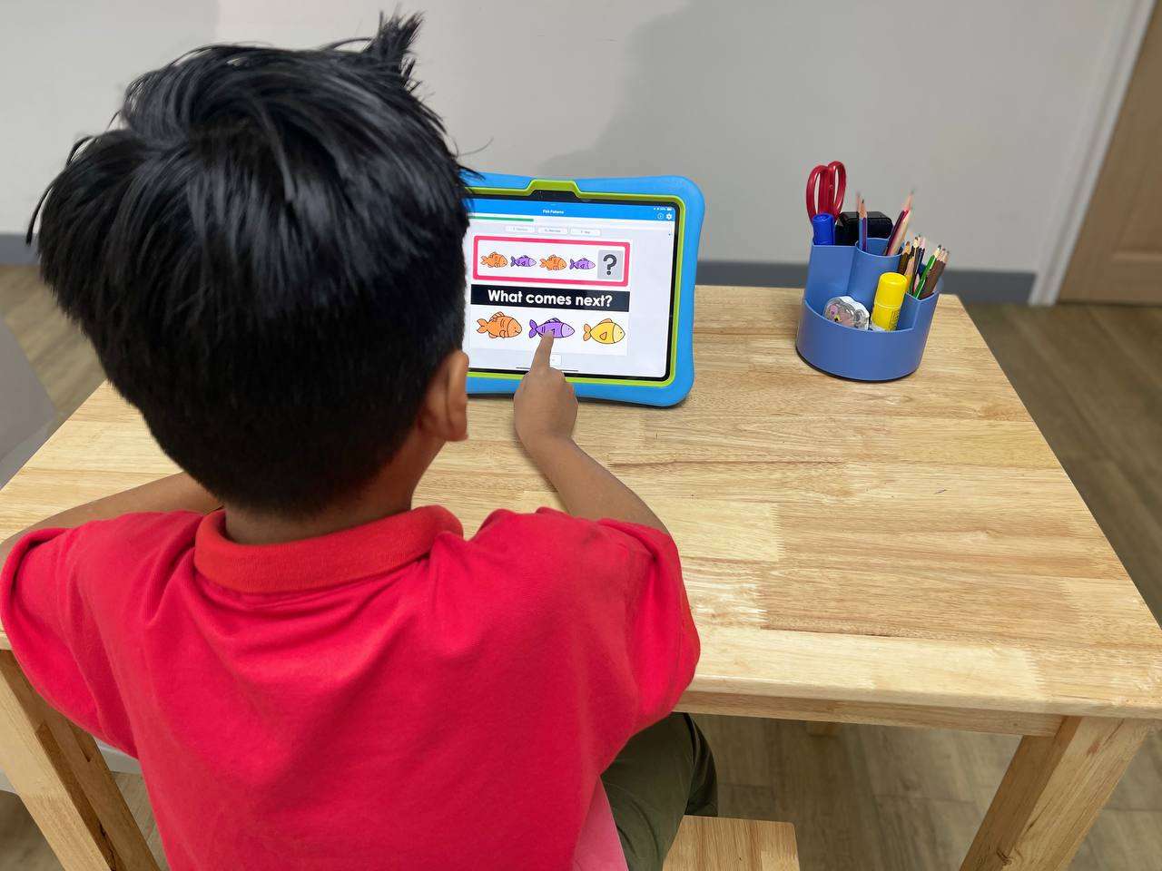 Child completing an on-screen “What comes next?” pattern activity during a learning session.