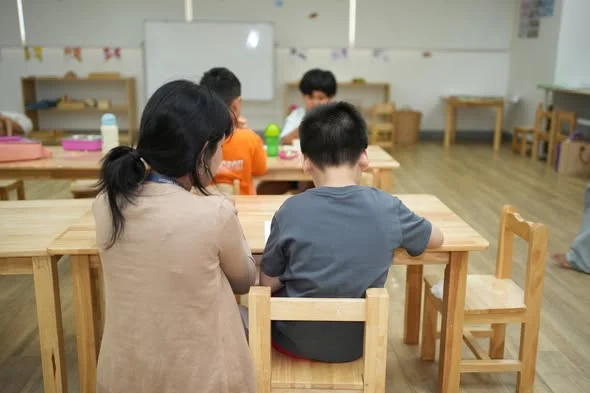 Teaching assistant providing one-to-one classroom support to a young learner at OrbRom Learning Support Center