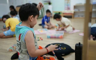 Child practicing fine-motor and focus skills during a structured preschool activity at OrbRom Center