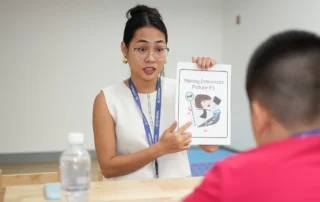 SPED teacher guiding a student through an inference-based learning activity at OrbRom Center
