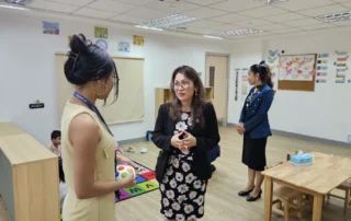Staff from Vision Bridge International Academy and OrbRom Center discussing inclusive education strategies inside a classroom in Phnom Penh.
