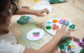 Preschool children painting and exploring colors during a classroom art activity