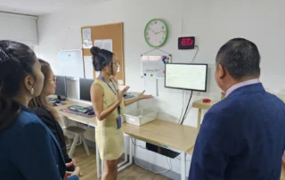 School representative presenting classroom resources and learning support tools during an inclusive education collaboration visit in Phnom Penh.