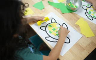 Child engaging in a cutting and pasting activity to develop coordination and focus