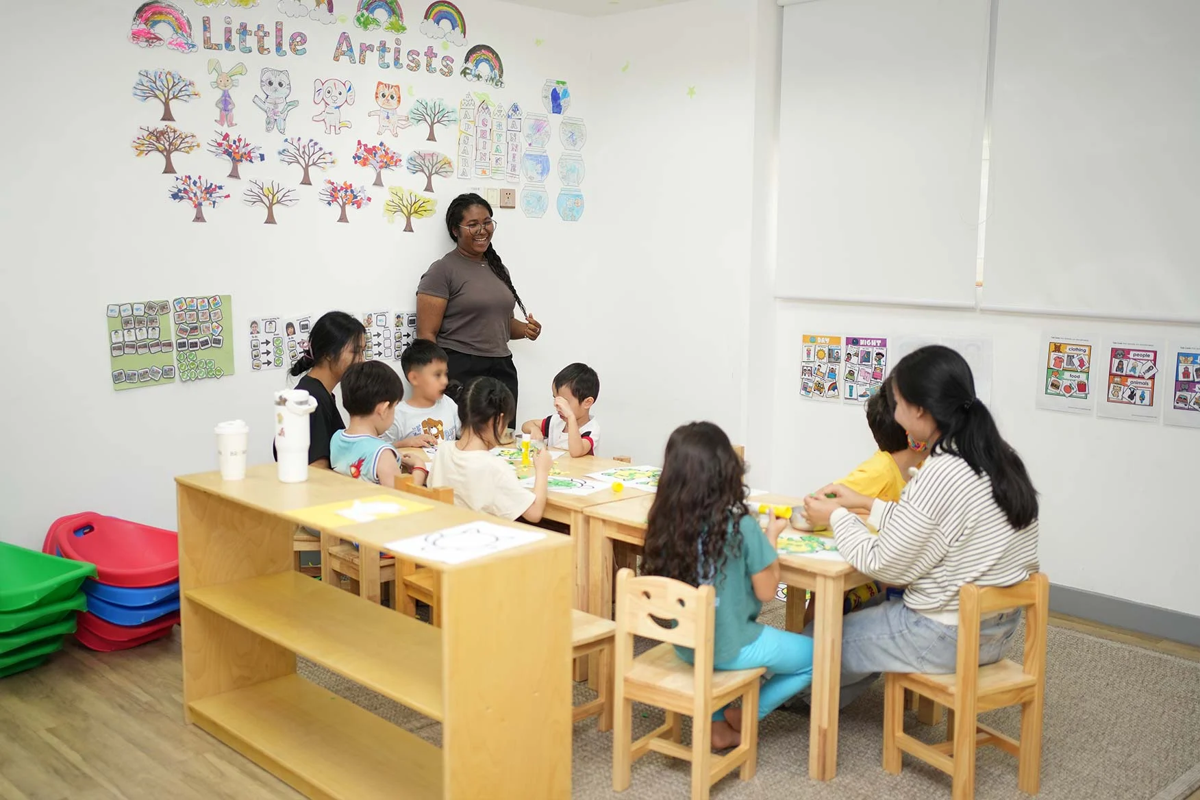 Children participating in structured group activity in a preschool classroom with teacher guidance