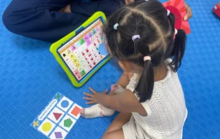 Chinese speech therapy session using AAC communication device and shape sorting activities in Phnom Penh