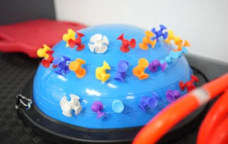 Colorful suction toys on a balance dome used for fine motor skills and sensory play.