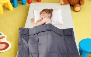 Child using a weighted sensory blanket for calming and relaxation
