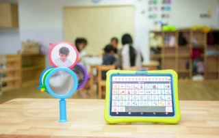 Close-up of AAC communication tools including emotion cards and a therapy mirror used to support speech and language development in children.
