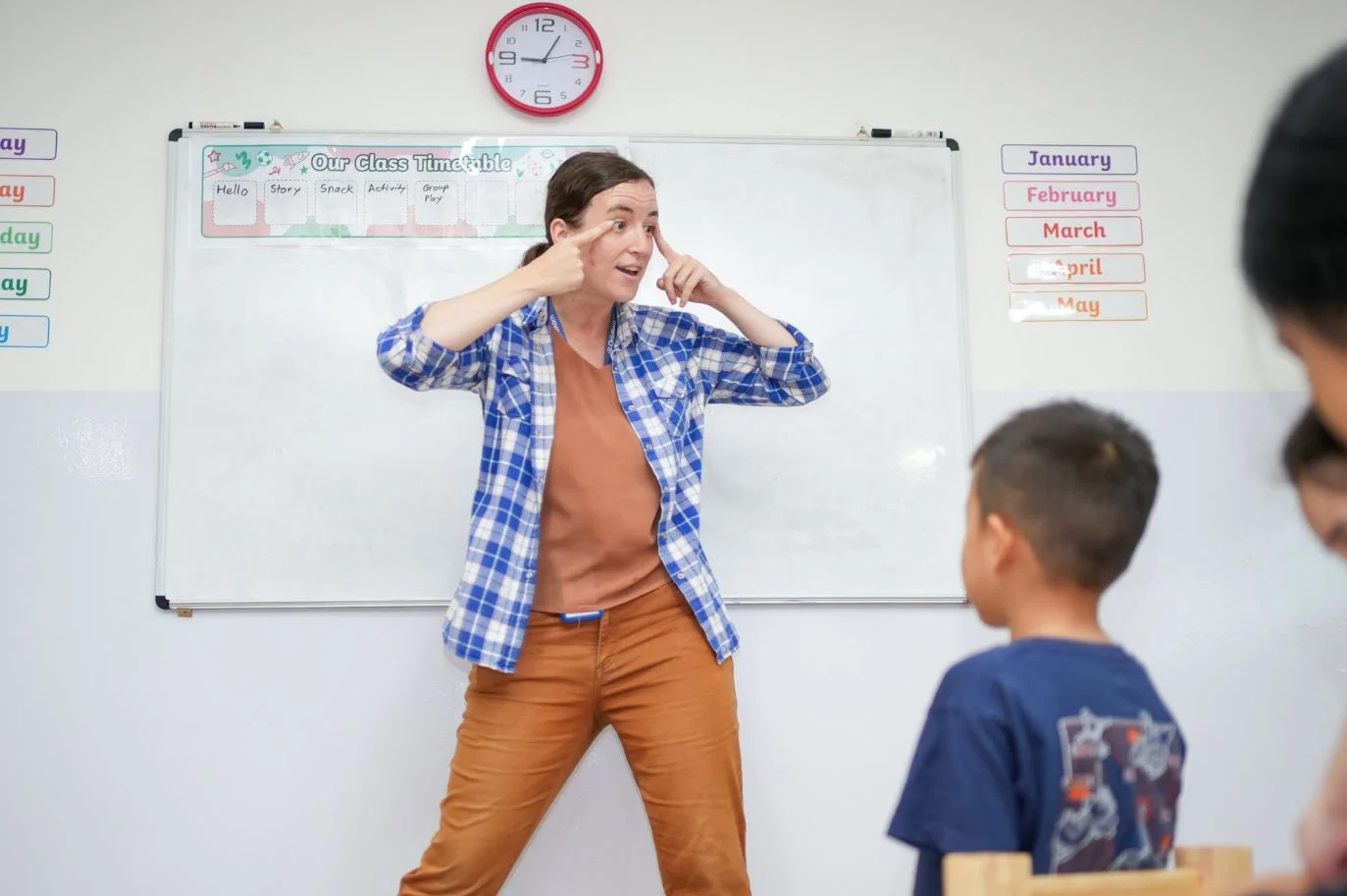 Kate, Lead Teacher at OrbRom Learning Support Center, uses expressive gestures and animated teaching to engage students during an interactive classroom lesson.